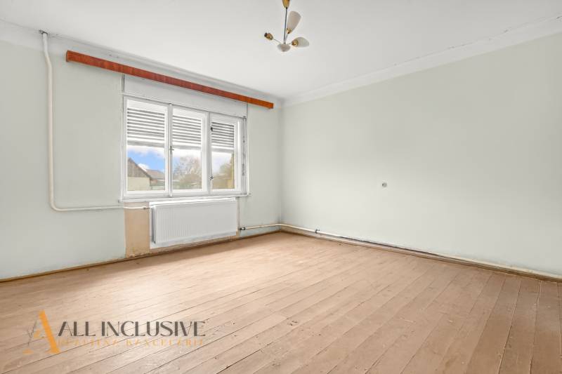 REZERVOVANÉ 4-IZBOVÝ RODINNÝ DOM, TOPOĽNÍKY - Prázdna miestnosť v rodinnom dome s podlahou s dreveným dekorom a veľkým oknom.