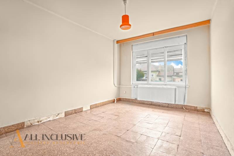 REZERVOVANÉ 4-IZBOVÝ RODINNÝ DOM, TOPOĽNÍKY - Priestranná izba s podlahou z kachličiek v rodinnom dome, neutrálne steny a veľké okno.