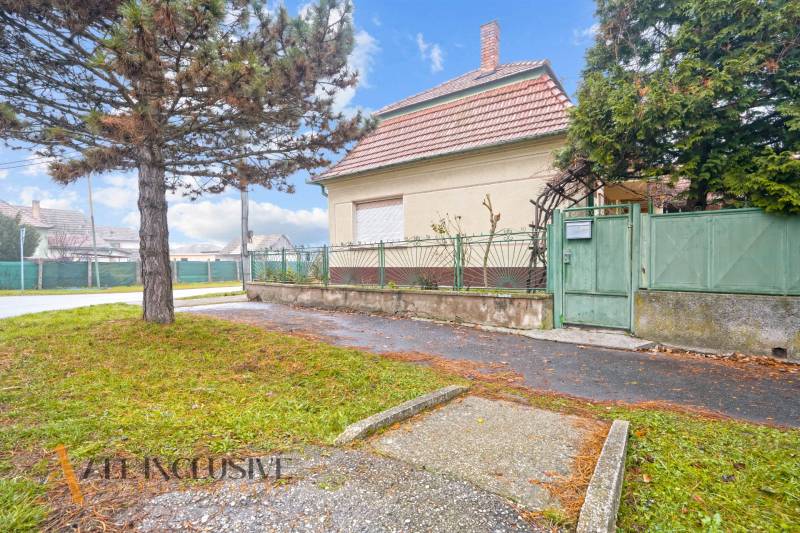 REZERVOVANÉ 4-IZBOVÝ RODINNÝ DOM, TOPOĽNÍKY - Rodinný dom v Topoľníkoch s veľkým stromom a kovovým plotom.