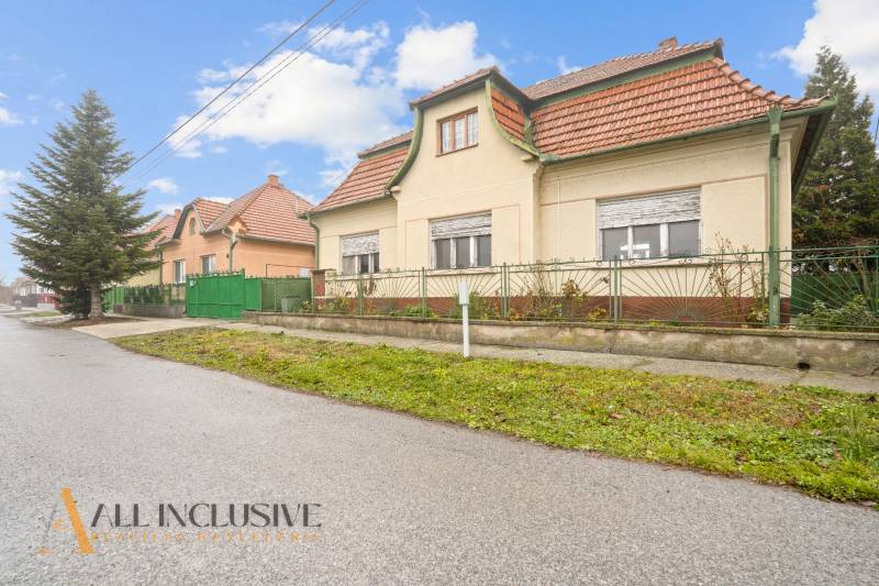 REZERVOVANÉ 4-IZBOVÝ RODINNÝ DOM, TOPOĽNÍKY - Rodinný dom v Topoľníkoch so šikmou strechou a zeleným plotom pozdĺž ulice.