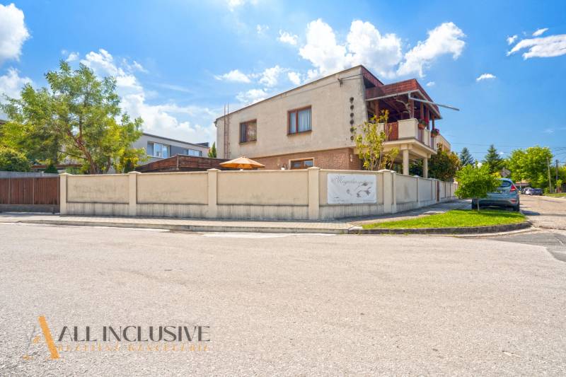 NA PREDAJ APARTMÁNOVÝ DOM VO VEĽKOM MEDERI - Budova v meste Veľký Meder s nápisom, obklopená zeleňou. Hotely a penzióny v okolí.