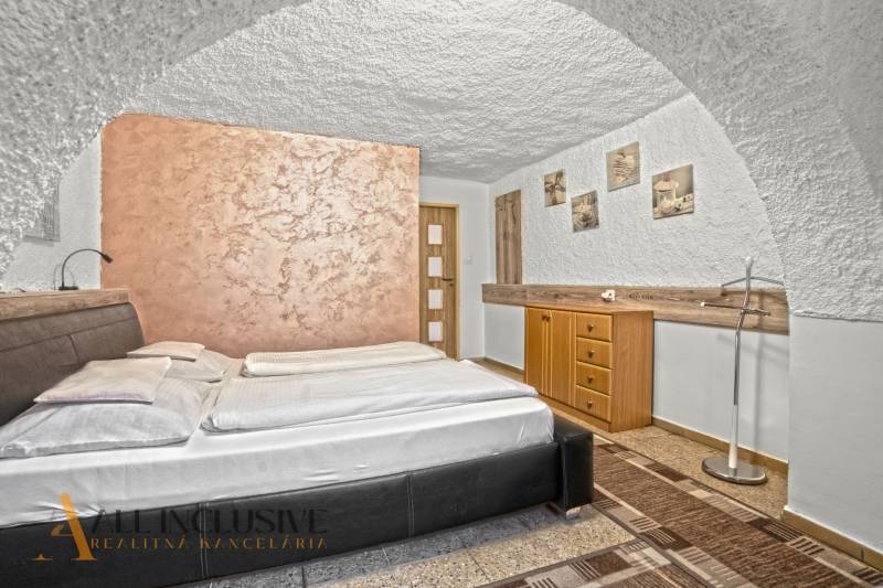 NA PREDAJ APARTMÁNOVÝ DOM VO VEĽKOM MEDERI - Izba s dvojposteľou, textúrovanými stenami, dekoratívnymi obrazmi a lampou v hoteli a penzióne.