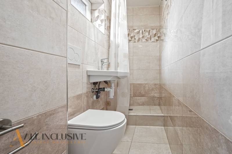 NA PREDAJ APARTMÁNOVÝ DOM VO VEĽKOM MEDERI - Kúpeľňa s toaletou, sprchou, umývadlom a obkladom v svetlých tónoch vhodná pre Hotely a penzióny.