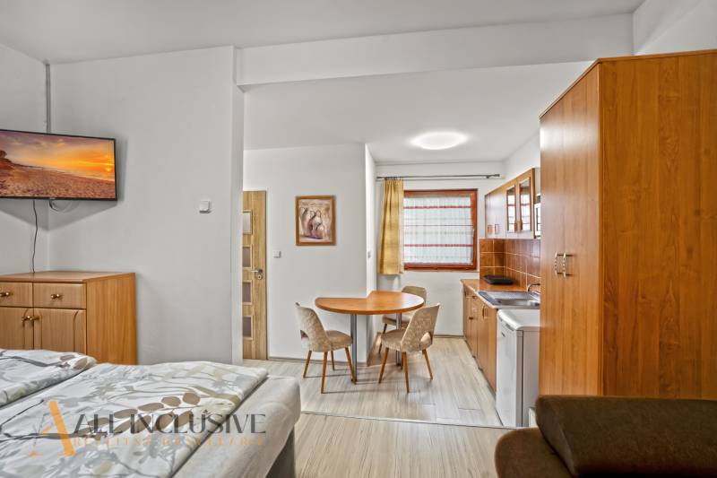 NA PREDAJ APARTMÁNOVÝ DOM VO VEĽKOM MEDERI - Interiér hotela a penziónu so zariadením, kuchynskou linkou a podlahou s dreveným dekorom.