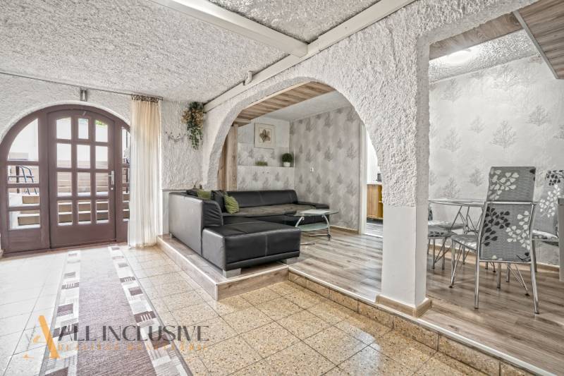 NA PREDAJ APARTMÁNOVÝ DOM VO VEĽKOM MEDERI - Interiér s čiernou sedacou súpravou, stolíkom a podlahou s dreveným dekorom, Hotely a penzióny.