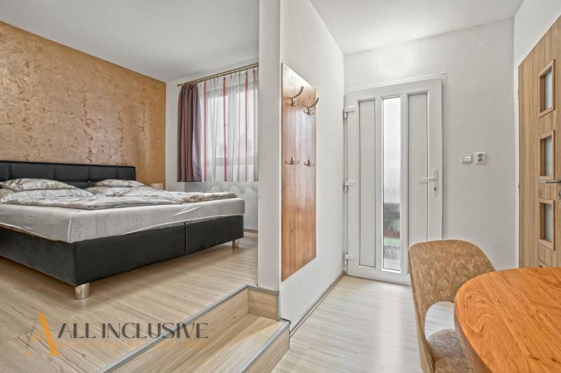 NA PREDAJ APARTMÁNOVÝ DOM VO VEĽKOM MEDERI - Ubytovacie priestory s posteľou, podlahou s dreveným dekorom, stolom a svetlým dizajnom. Hotely a penzióny.