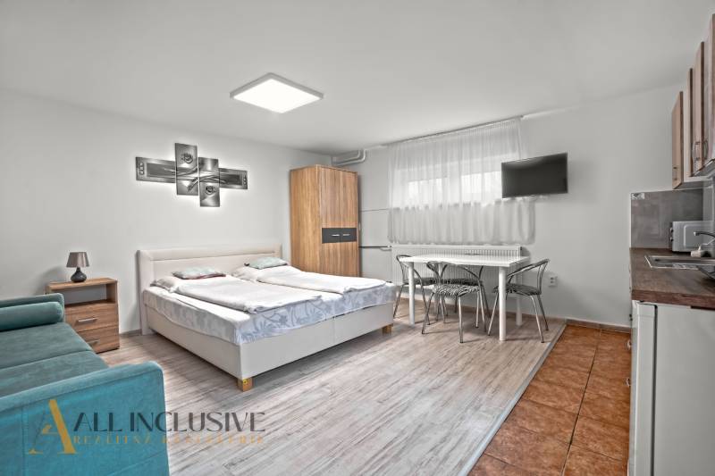 NA PREDAJ APARTMÁNOVÝ DOM VO VEĽKOM MEDERI - Pohodlná izba s posteľou, podlahou s dreveným dekorom a TV v Hotely a penzióny.