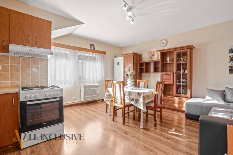 NA PREDAJ 6-IZBOVÝ POSCH. RODINNÝ DOM, HORNÉ SALIBY - Interiér rodinného domu s podlahou s dreveným dekorom, kuchyňou, jedálenským stolom a pohovkou.