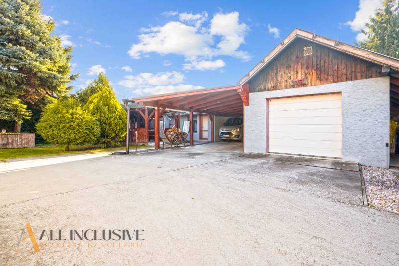 NA PREDAJ 6-IZBOVÝ POSCH. RODINNÝ DOM, HORNÉ SALIBY - Rodinný dom v Galante na ulici Horné Saliby s garážou a príjazdovou cestou, obklopený stromami.