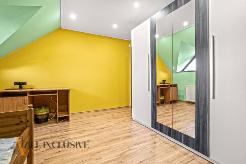 NA PREDAJ 6-IZBOVÝ POSCH. RODINNÝ DOM, HORNÉ SALIBY - Interiér s podlahou s dreveným dekorom, žltou stenou a zrkadlovým šatníkom v rodinnom dome.