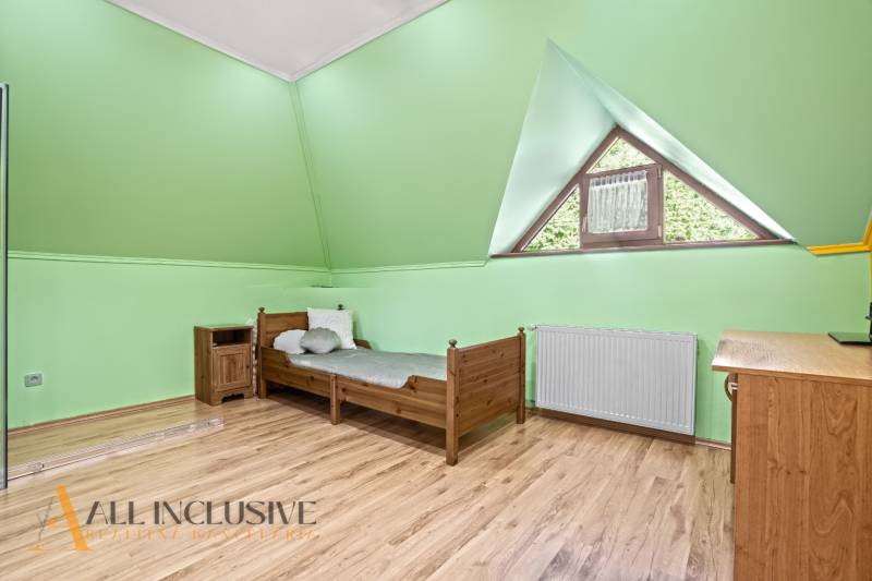 NA PREDAJ 6-IZBOVÝ POSCH. RODINNÝ DOM, HORNÉ SALIBY - Zelená izba s dreveným nábytkom a podlahou s dreveným dekorom v rodinnom dome.