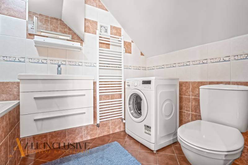 NA PREDAJ 6-IZBOVÝ POSCH. RODINNÝ DOM, HORNÉ SALIBY - Kúpeľňa v rodinnom dome s práčkou, umývadlom, toaletou a dizajnovými dlaždicami.