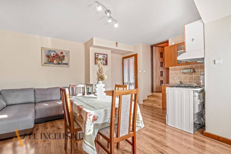 NA PREDAJ 6-IZBOVÝ POSCH. RODINNÝ DOM, HORNÉ SALIBY - Jedálenský kút v rodinnom dome s pohovkou, dreveným dekorom a kvetinovým obrazom.