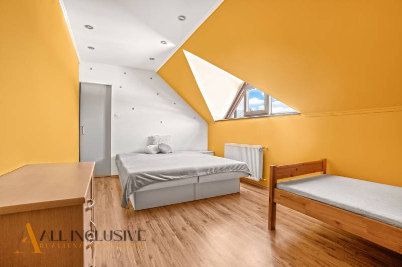 NA PREDAJ 6-IZBOVÝ POSCH. RODINNÝ DOM, HORNÉ SALIBY - Svetlá izba v rodinnom dome s podlahou s dreveným dekorom a farebnými stenami.