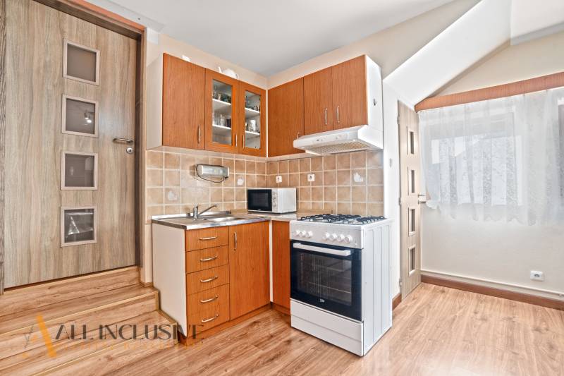 NA PREDAJ 6-IZBOVÝ POSCH. RODINNÝ DOM, HORNÉ SALIBY - Kuchynský kút v rodinnom dome s podlahou s dreveným dekorom a spotrebičmi.