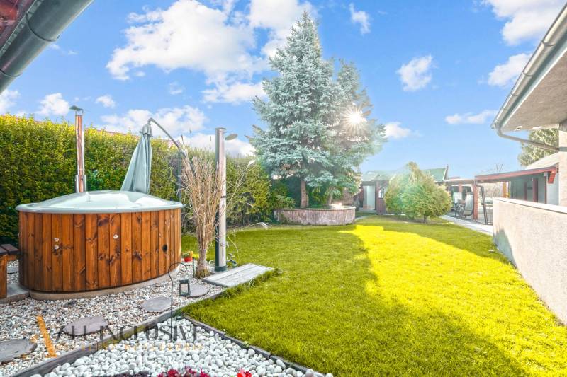 NA PREDAJ 6-IZBOVÝ POSCH. RODINNÝ DOM, HORNÉ SALIBY - Záhrada rodinného domu na Horných Salibách v Galante s drevenou vírivkou a stromami.