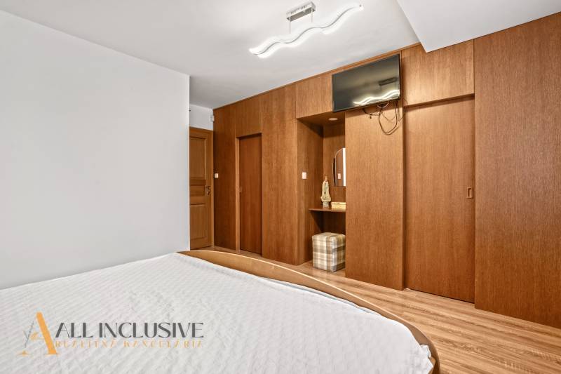 NA PREDAJ 6-IZBOVÝ POSCH. RODINNÝ DOM, HORNÉ SALIBY - Spálňa v rodinnom dome s posteľou a šatníkovou skriňou s dreveným dekorom.