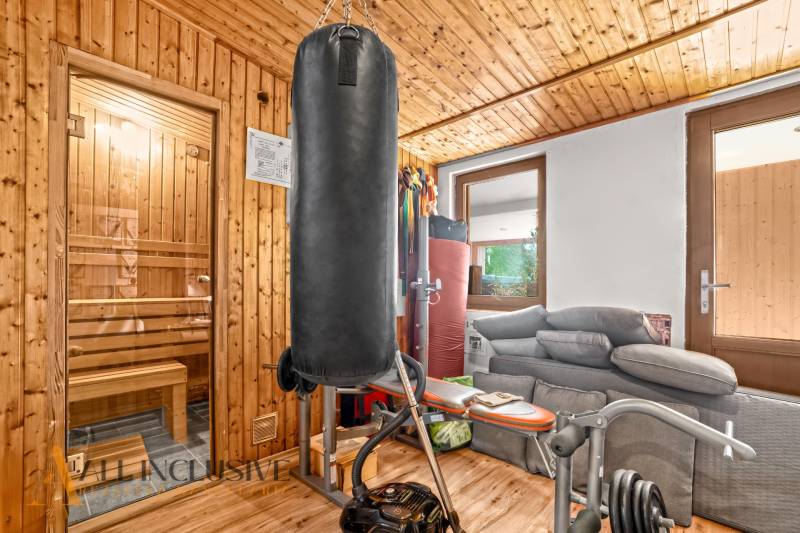 NA PREDAJ 6-IZBOVÝ POSCH. RODINNÝ DOM, HORNÉ SALIBY - Domáca telocvičňa v rodinnom dome s boxovacím vrecom a saunou, podlaha s dreveným dekorom.