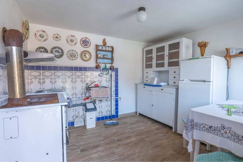 ZĽAVA - 3 IZBOVÝ RODINNÝ DOM, BLÍZKO CENTRA DUN.STREDY - Rustikálna kuchyňa v rodinnom dome so starožitnými taniermi a kachľami, podlaha s dreveným dekorom.