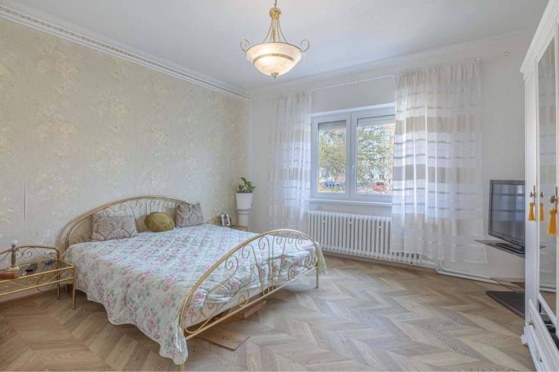 ZĽAVA - 3 IZBOVÝ RODINNÝ DOM, BLÍZKO CENTRA DUN.STREDY - Spálňa v rodinnom dome s postelí, květinovými tapetami a podlahou s dreveným dekorom.