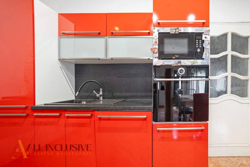 NA PREDAJ RODINNÉ DOMY S GARÁŽOU, DUNAJSKÁ STREDA - Červená kuchyňa v rodinnom dome s drezom a zabudovanou rúrou.