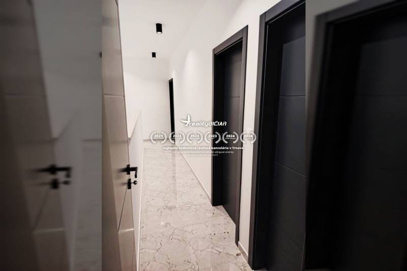 VRSI - dvojdom s bazénom a záhradou - Chodba v rodinnom dome s dlažbou a tmavými dverami.