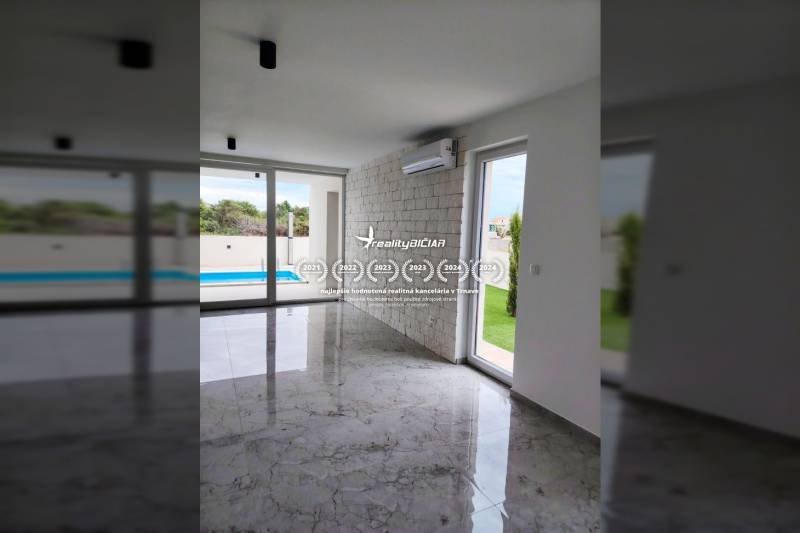 VRSI - dvojdom s bazénom a záhradou - Interiér rodinného domu s klimatizáciou, veľkými oknami a výhľadom na bazén.