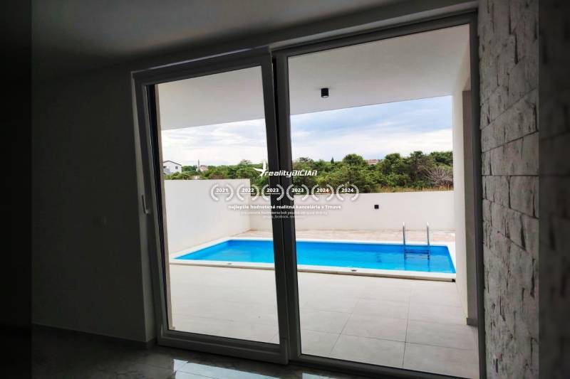 VRSI - dvojdom s bazénom a záhradou - Výhľad z rodinného domu na terasu s bazénom, podlaha s dreveným dekorom.