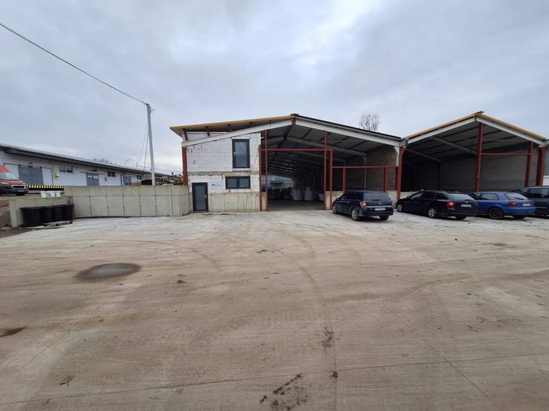 Na predaj sklad - hala, ul. Strojnícka, Prešov - Priemyselná budova na Strojníckej ulici v Prešove s parkovacími miestami a autami.