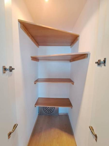 Prenájom pekného a priestranného 4-izbového bytu vo Svite - Šatník so vstavanými policami v 4-izbovom byte s podlahou s dreveným dekorom.