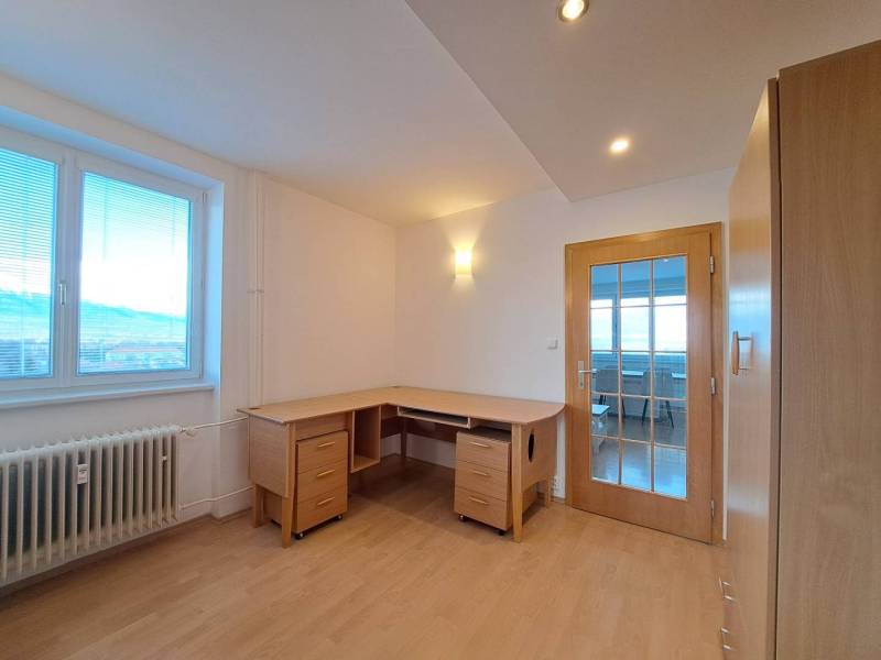 Prenájom pekného a priestranného 4-izbového bytu vo Svite - Pracovňa v 4-izbovom byte s podlahou s dreveným dekorom a písacím stolom.