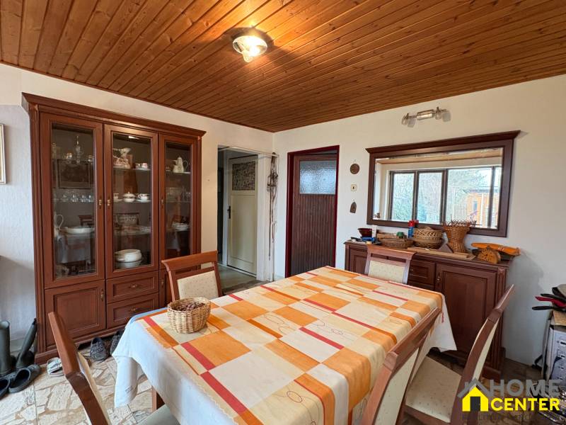 Exkluzívny PREDAJ 4 izbového rodinný domu s garážou, Zlatná na Ostrove - Jedáleň v rodinnom dome so stolom, stoličkami a skriňou, podlaha s dreveným dekorom.