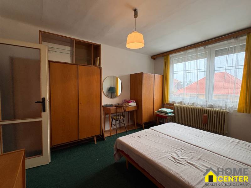 Exkluzívny PREDAJ 4 izbového rodinný domu s garážou, Zlatná na Ostrove - Spálňa rodinného domu s kobercovou podlahou, dreveným nábytkom a veľkým oknom.