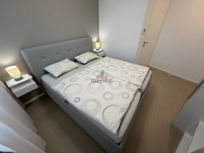 Exk. prenájom lux. 2 iz bytu Rezidencia Blumental - Spálňa s manželskou posteľou a podlahou s dreveným dekorom v 2-izbovom byte.