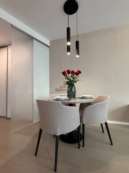 Exk. prenájom lux. 2 iz bytu Rezidencia Blumental - Jedálenský kút so stolom a stoličkami, podlaha s dreveným dekorom v 2-izbovom byte.