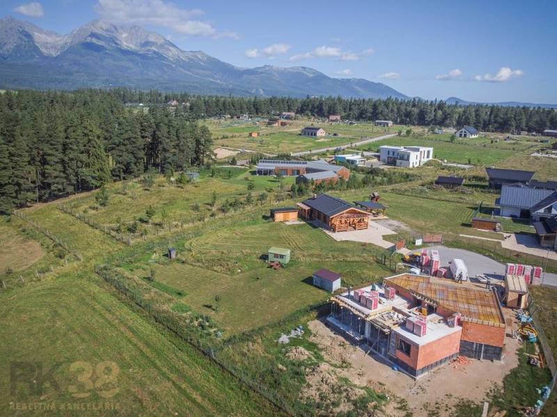 Jedinečný stavebný pozemok v krásnej lokalite Tatranské Smaragdy - Pozemky - bývanie v Mlynici s výhľadom na hory a rozostavanými domami v prírode.