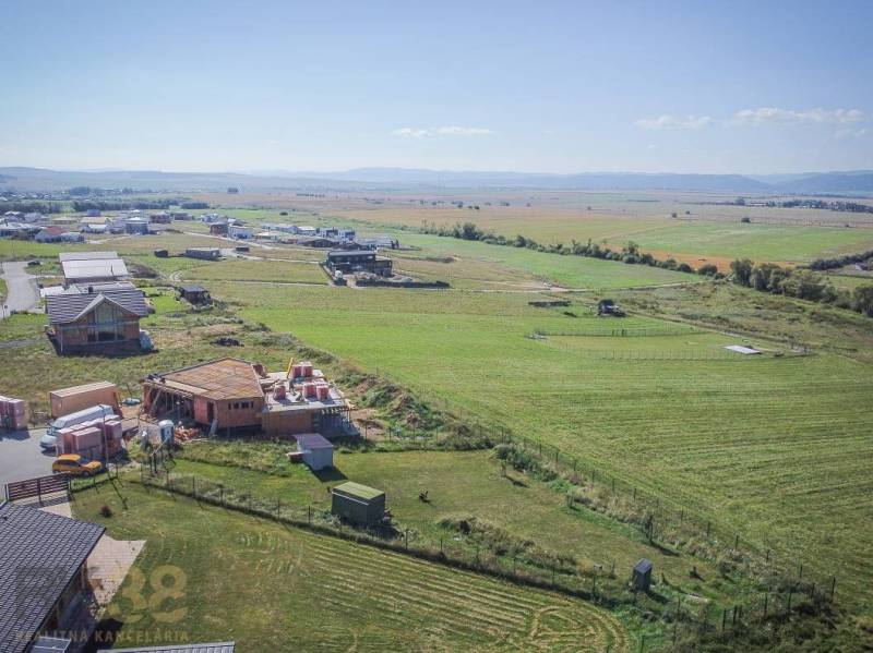 Jedinečný stavebný pozemok v krásnej lokalite Tatranské Smaragdy - Pozemky - bývanie v Mlynici; rozostavané domy a rozsiahle polia pod slnečnou oblohou.