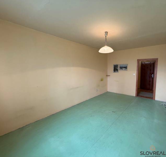 Ponúka na predaj 3 izbový byt v Detve - Izba v 3-izbovom byte s neutrálnymi stenami a svetlým podlahovým dekorom.