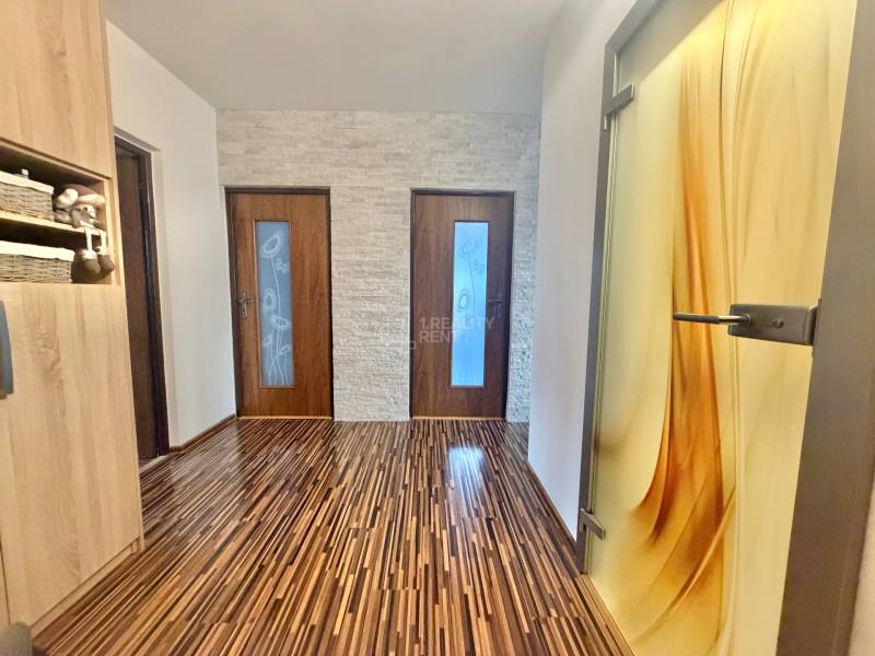 Prejaj nadčasového 4+1 bytu v skvelej lokalite Čadca- Žarec - Interiér 4-izbového bytu s podlahou s dreveným dekorom a dekoratívnymi dverami.