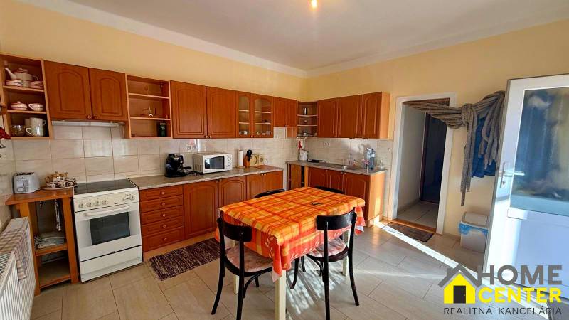 NA PREDAJ 5 izbový rodinný dom s veľkou záhradou v obci Iža - Kuchyňa v rodinnom dome s dreveným dekórom a jedálenským stolom.