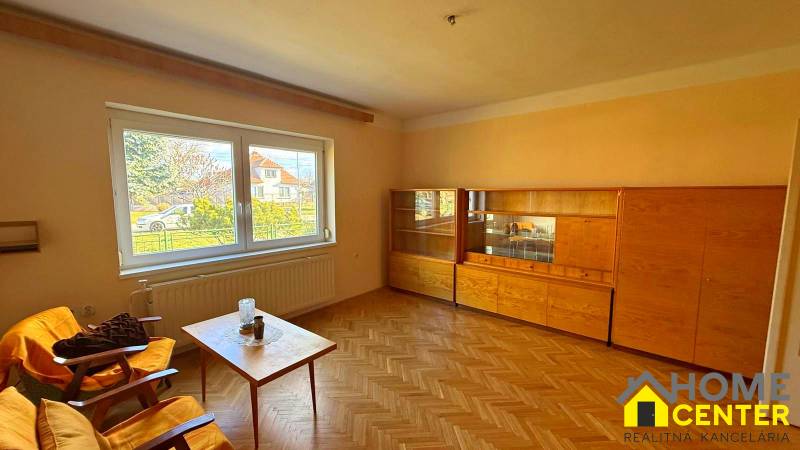 NA PREDAJ 5 izbový rodinný dom s veľkou záhradou v obci Iža - Obývačka v rodinnom dome s nábytkom a podlahou s dreveným dekorom.