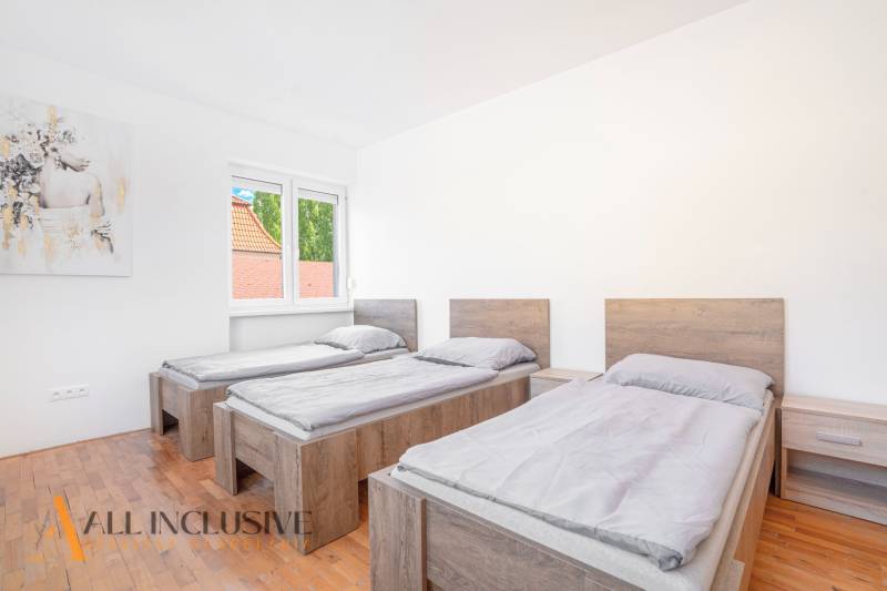 Na predaj 7-izb. RD s obchod. priestorom, Dun. Streda - Tri postele v izbe s podlahou s dreveným dekorom a obrazom na stene.