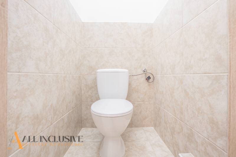 Na predaj 7-izb. RD s obchod. priestorom, Dun. Streda - Toaleta obložená svetlými obkladačkami v budove.