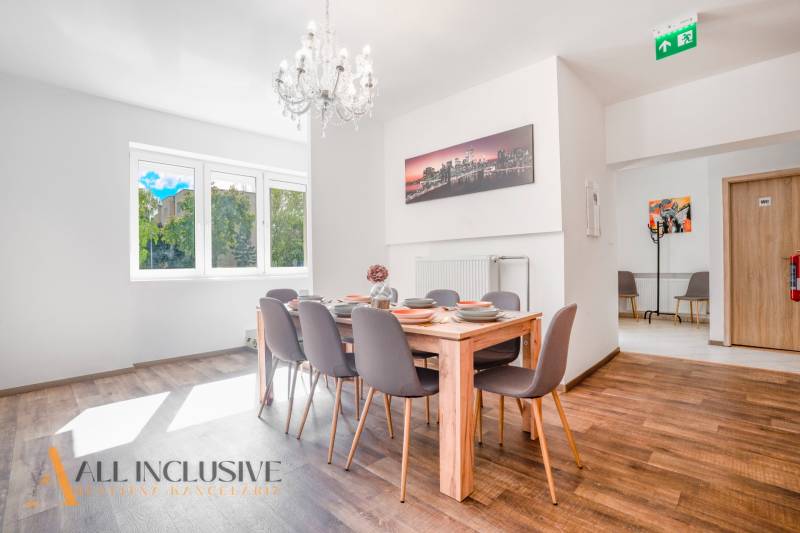 Na predaj 7-izb. RD s obchod. priestorom, Dun. Streda - Jedáleň s lusterom a podlahou s dreveným dekorom v budove.