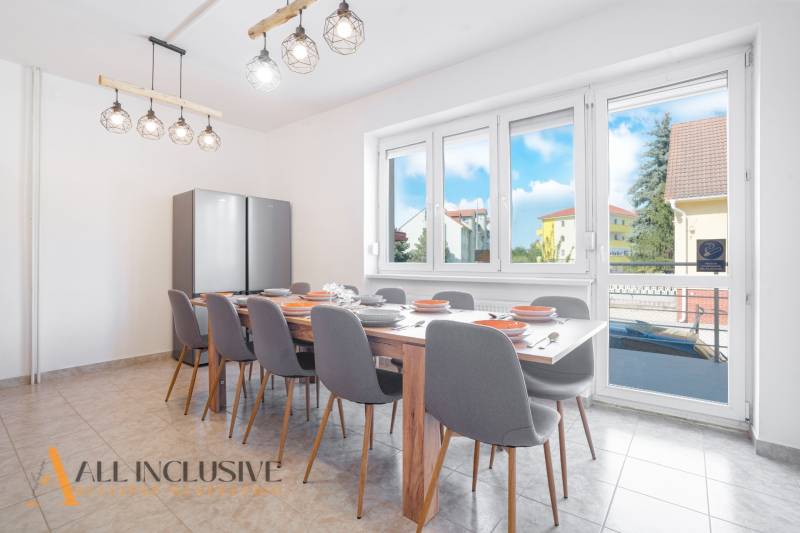 Na predaj 7-izb. RD s obchod. priestorom, Dun. Streda - Jedáleň v budove s veľkým stolom a pohľadom na Dunajskú Stredu.