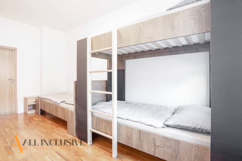 Na predaj 7-izb. RD s obchod. priestorom, Dun. Streda - Interiér s poschodovou posteľou a podlahou s dreveným dekorom v budove.