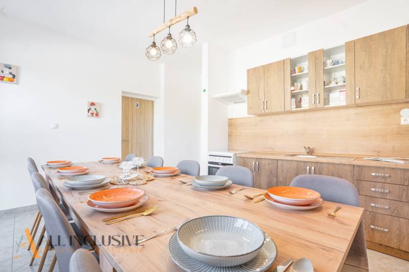 Na predaj 7-izb. RD s obchod. priestorom, Dun. Streda - Kuchyňa v budove, drevené skrinky, veľký stôl s podlahou s dreveným dekorom.