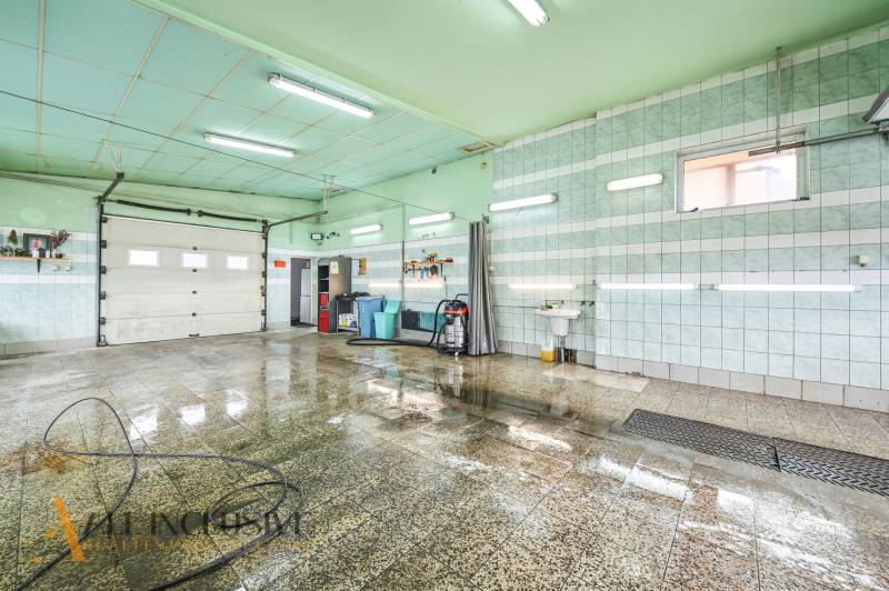 Na predaj 7-izb. RD s obchod. priestorom, Dun. Streda - Miestnosť v budove s mokrou dlažbou, umývadlom a hadicou na stene.