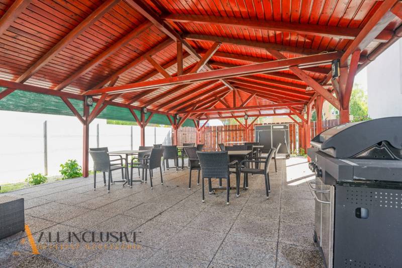 Na predaj 7-izb. RD s obchod. priestorom, Dun. Streda - Exteriérová terasa budovy v Dunajskej Strede s drevenou strechou a grilom.