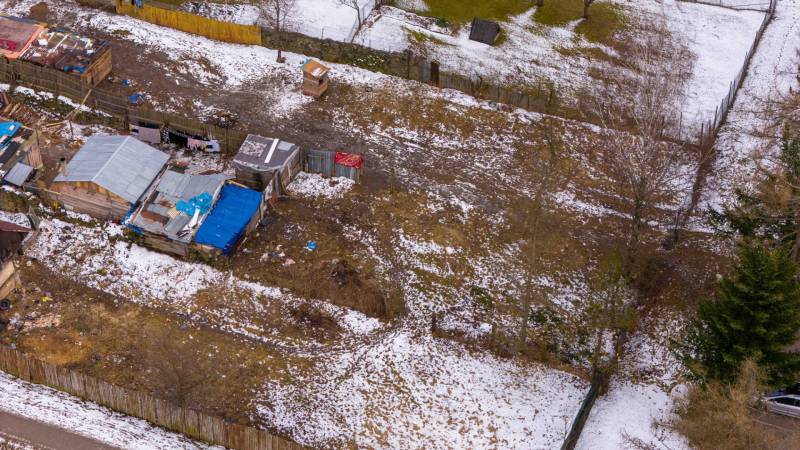 Nálepkovo – 99 m2 STAVEBNÝ pozemok v obci - Záhrady v Nálepkove so zaľadneným snehom, staršími prístreškami a oploteniami v zime.